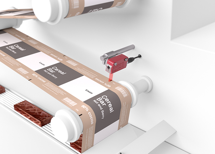 Cảm biến contrast Leuze trong máy đóng gói dạng ống — phát hiện print mark để định vị cắt đúng vị trí
